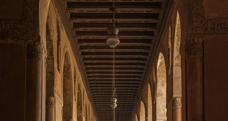 Plafond avec des sculptures en bois complexes et des lampes suspendues.