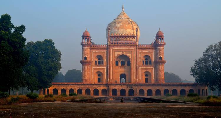 Mausoleum surrounded by greenery at sunrise