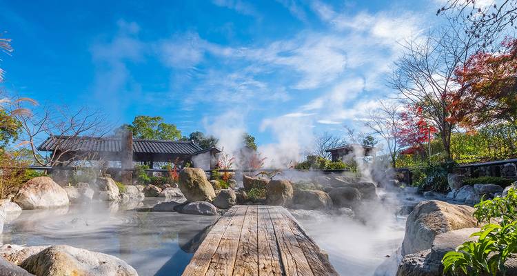 Source chaude pittoresque avec vapeur et architecture japonaise traditionnelle.