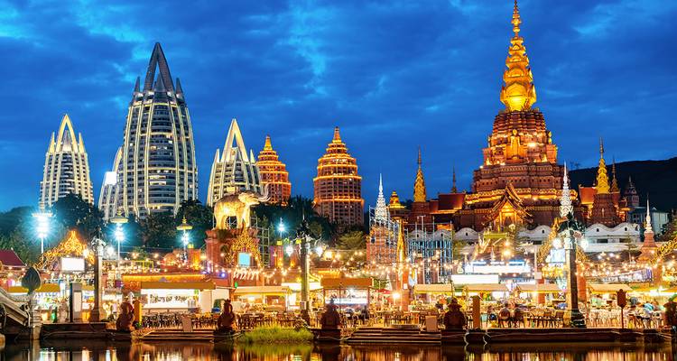Bâtiments brillamment éclairés et structures semblables à des temples dans un paysage urbain.