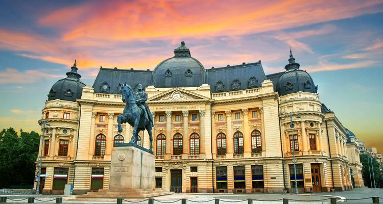 La Bibliothèque Universitaire Centrale de Bucarest avec un ciel de coucher de soleil.