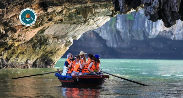 Des touristes dans une petite embarcation explorent une grotte en portant des gilets de sauvetage.