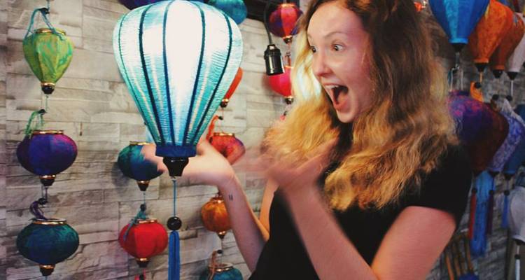 Femme ravie par une lanterne colorée dans une boutique.