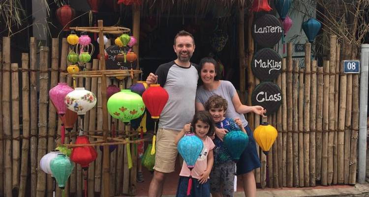 Famille posant avec des lanternes colorées devant un magasin de fabrication de lanternes.
