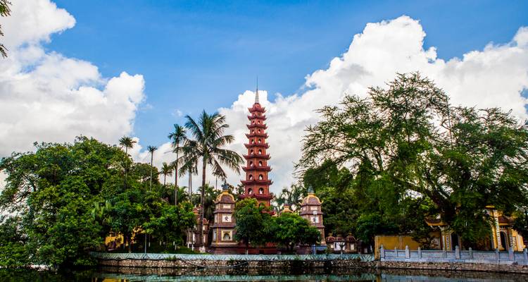 Pagode entourée d'arbres et d'un plan d'eau.