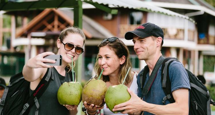 Trois personnes savourant des noix de coco et prenant un selfie.