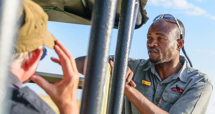 Two men conversing in a safari vehicle.