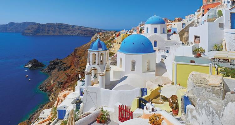 Iconic white houses with blue domes overlooking the sea.