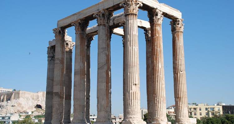 Ancient ruins with large columns under a clear sky.