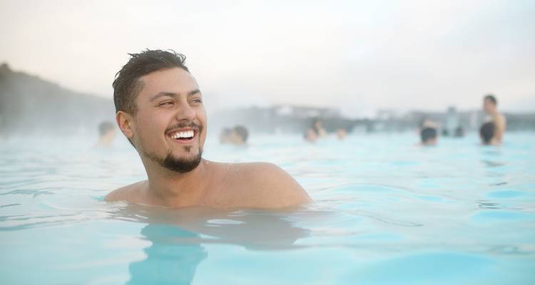 Man smiling while in a hot spring.