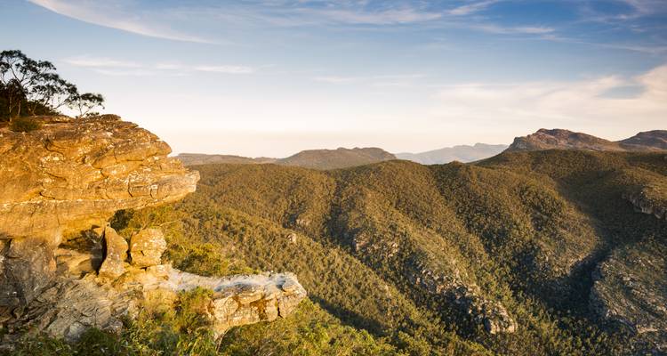 Expansive view of rugged mountain ranges under a partly cloudy sky.