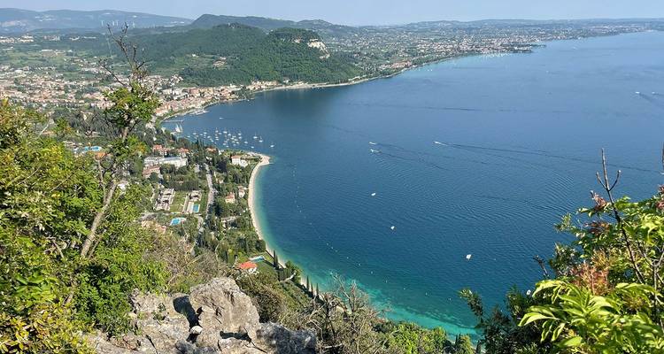 Vista panorámica de las aguas turquesas del Lago de Garda y las colinas que lo rodean.