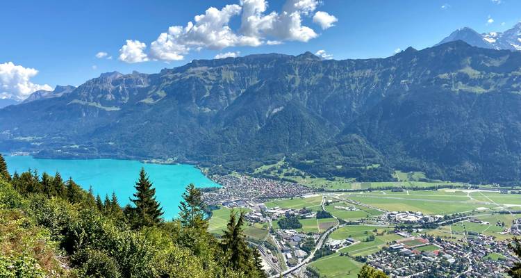 Vue panoramique d'une vallée avec un lac bleu.