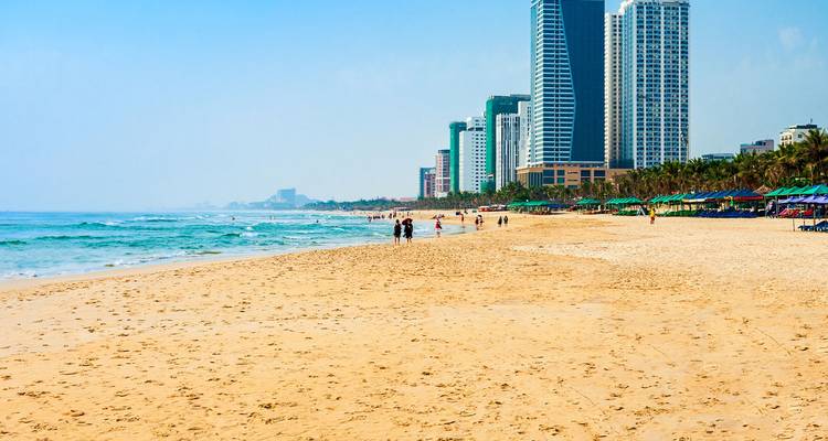 Der lange Sandstrand My Khe Beach in Da Nang erstreckt sich neben sanften Wellen und modernen Hochhaushotels, wo Besucher spazieren.