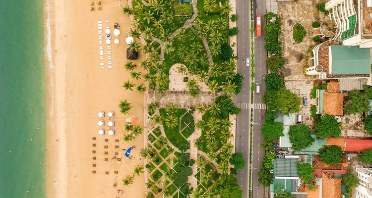 Aerial view of a coastal park with palm trees and beach access, likely Nha Trang.