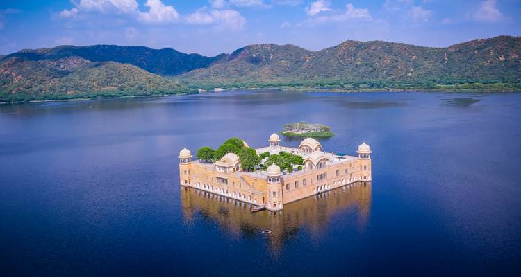 Jal Mahal situé au milieu d'un lac avec des collines.