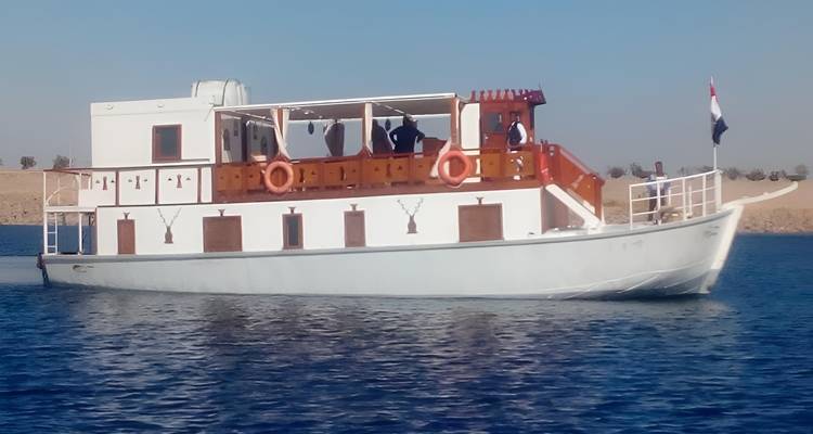 Traditional boat on a river or lake with a desert backdrop.
