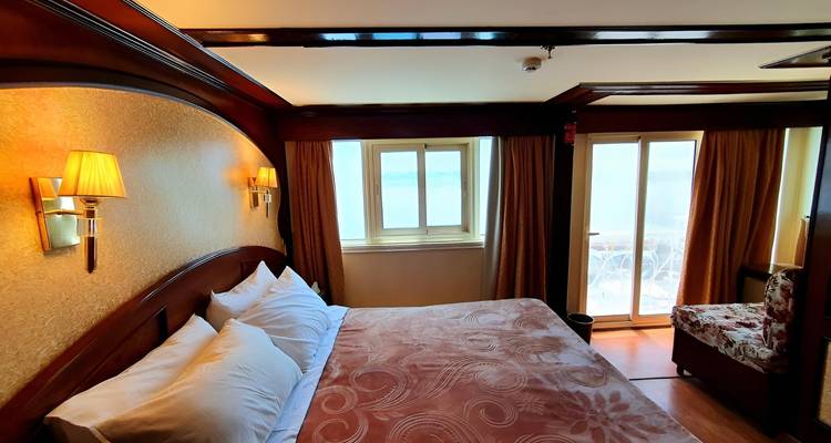 Well-decorated interior room with a bed and a window.
