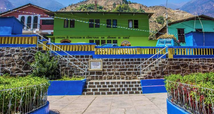 Colorful buildings and a central plaza with mountains in the background.