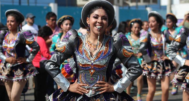Costumed dancers perform in a vibrant street parade.