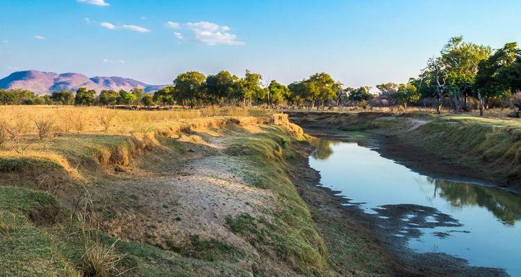 River winding through a dry landscape with distant hills.