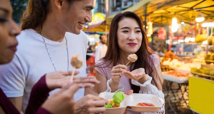 Group of people enjoying street food at a night market