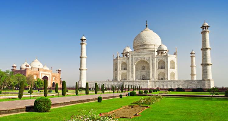 Taj Mahal in een goed onderhouden tuin onder een heldere blauwe hemel.