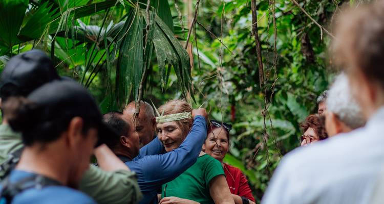Groupe de personnes dans la jungle, une personne recevant une coiffe