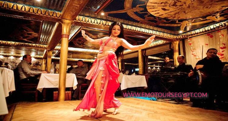 Danseuse du ventre se produisant dans une salle décorée devant un public.