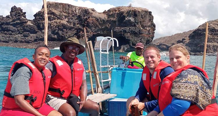 Des gens lors d'une excursion en bateau près de falaises rocheuses.