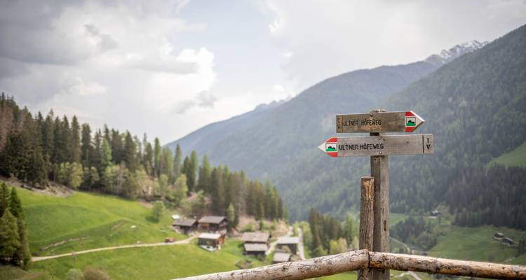 Wegweiser in einem malerischen Bergtal.