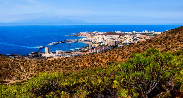Une ville côtière avec un port, des vues sur l'océan et des îles lointaines.