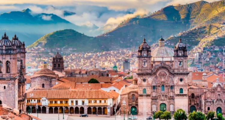 Una ciudad con arquitectura histórica y montañas de fondo en un entorno vibrante.