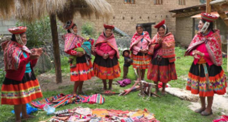 Locales con vestimenta tradicional reunidos en un entorno de pueblo.