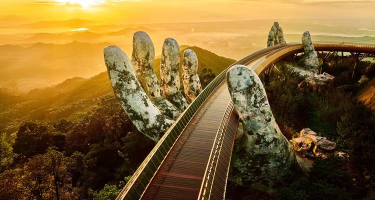 Célèbre pont à main avec une vue panoramique au coucher de soleil en arrière-plan.