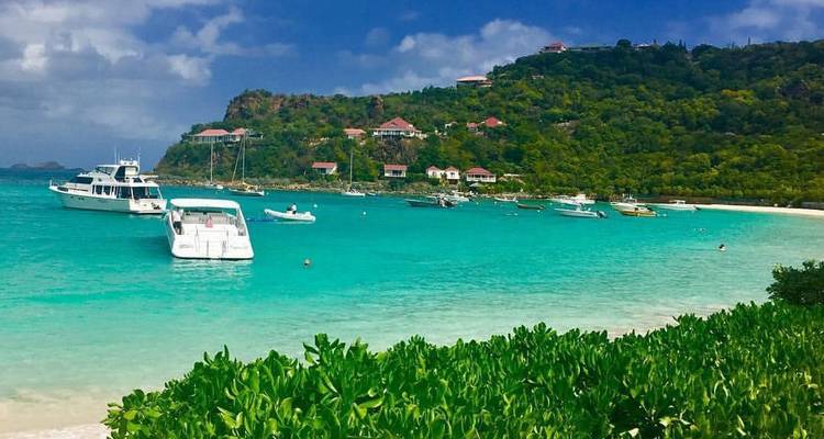 Bateaux ancrés dans des eaux turquoise avec des collines en arrière-plan.
