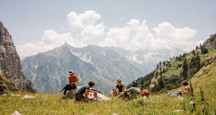 Groupe de personnes se reposant dans un pré de montagne.