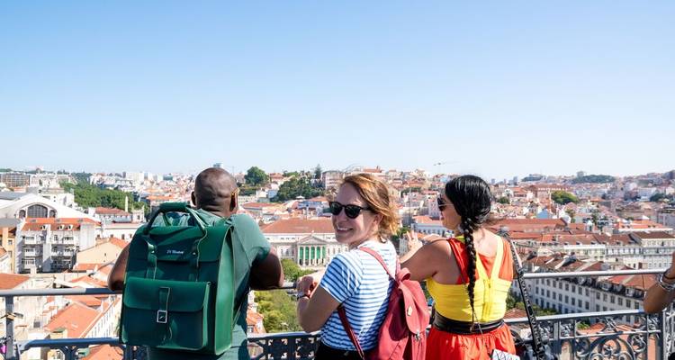People enjoying a panoramic view of a city with red rooftops.