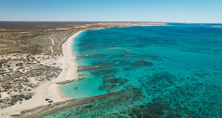 An aerial view of a breathtaking coastline with turquoise waters and sandy beaches.