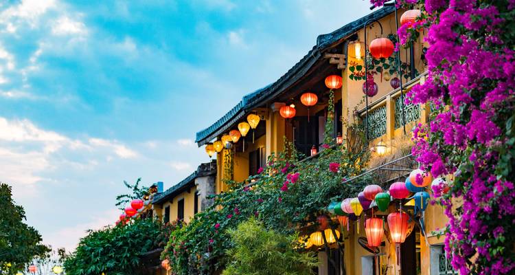 Building facades adorned with colorful lanterns and lush vegetation.