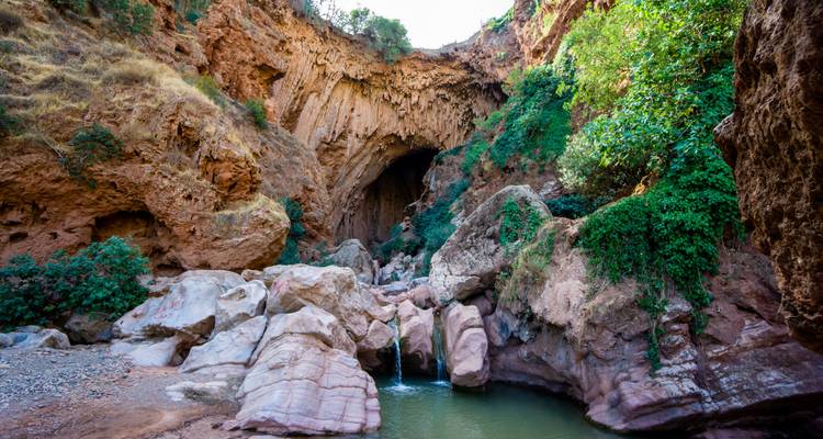 Felsiger Höhleneingang mit Wasserbecken.