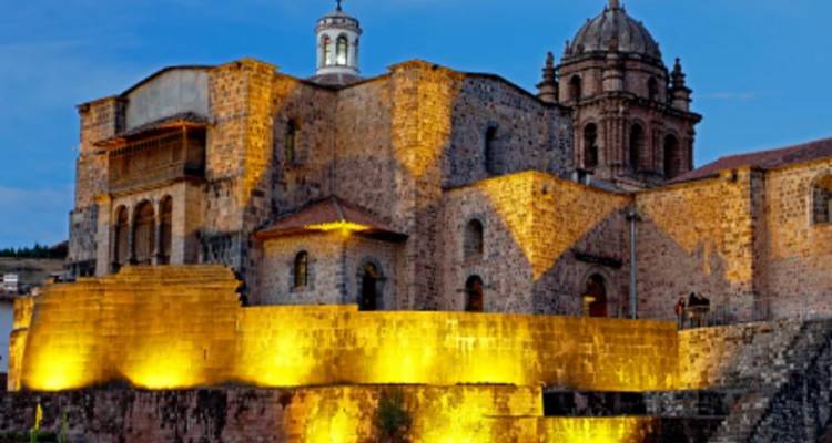 Un bâtiment historique en pierre illuminé la nuit.