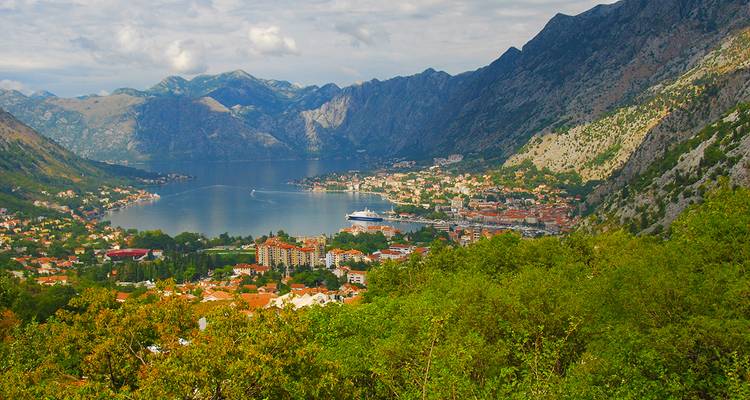 Vista panorámica de un pueblo costero rodeado de montañas en Montenegro.