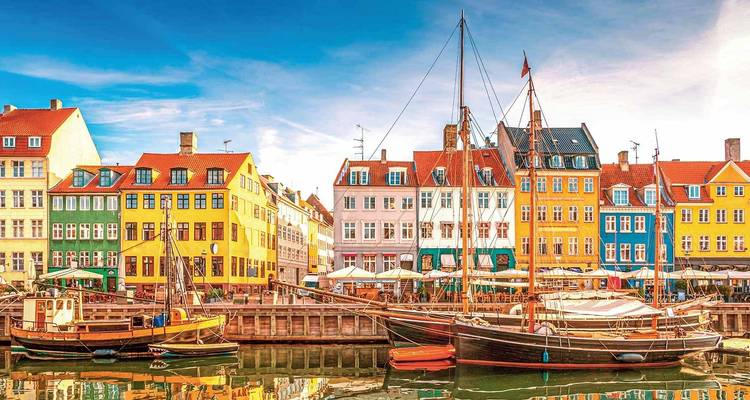 Colorful historical waterfront houses with boats in front.