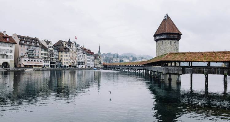 View of a wooden bridge over a river with traditional architecture.