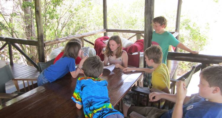 Children gathered around a table in an outdoor setting.