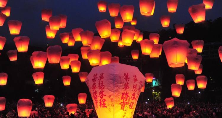 Ciel nocturne rempli de lanternes chinoises illuminées créant une atmosphère festive.