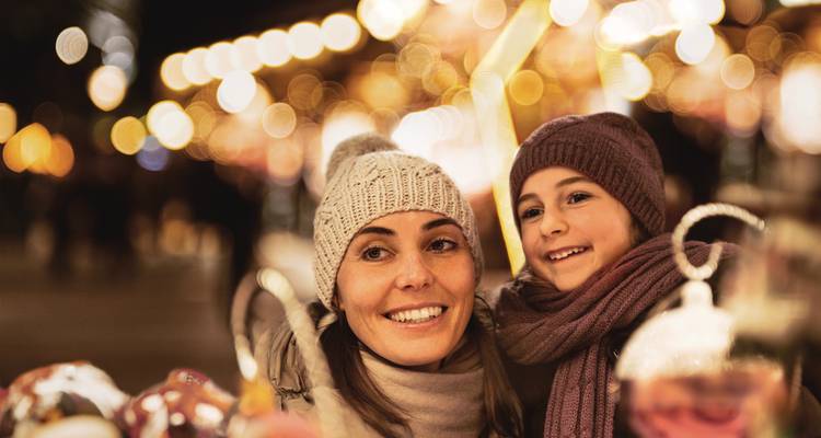 Mère et fille profitant d'un marché de Noël la nuit.