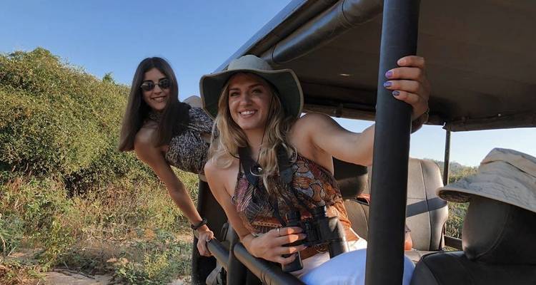 Two women posing in a safari vehicle.