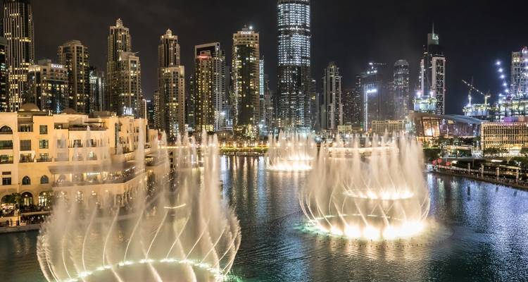 The Dubai Fountain at night, with the city skyline illuminated in the background.